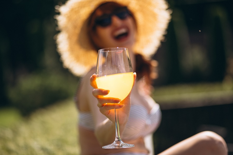 donna che mostra calice con orange wine non filtrato